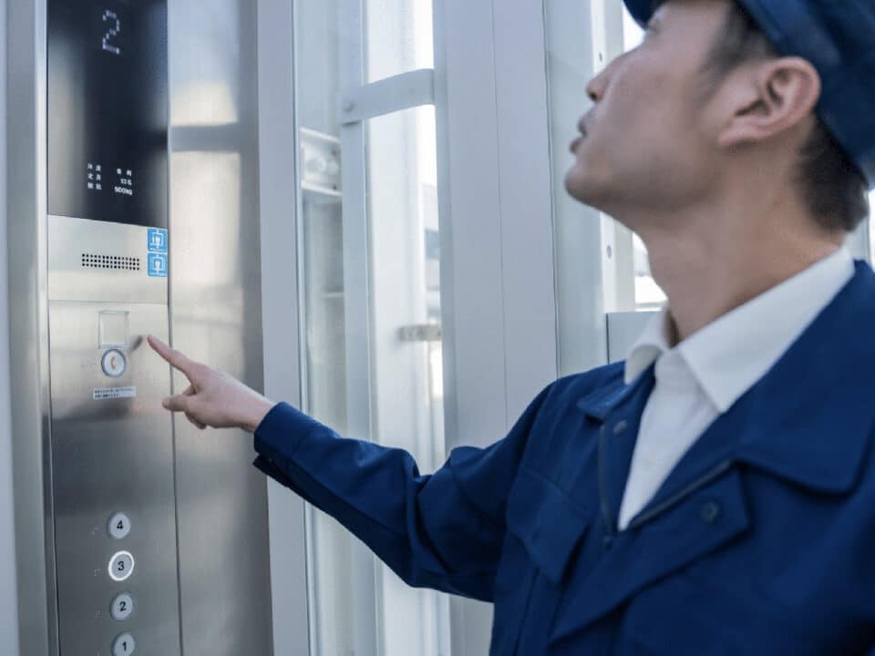 operator in elevator pointing to phone button